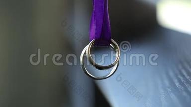 黄金结婚戒指在紫色丝带宏观特写拍摄钻石珠宝